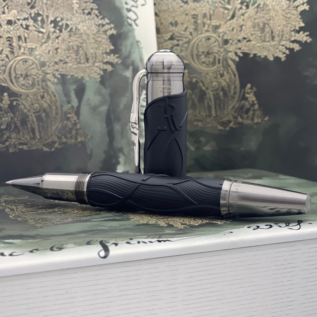 Montblanc Grimm Rollerball geöffnet auf Buch liegend